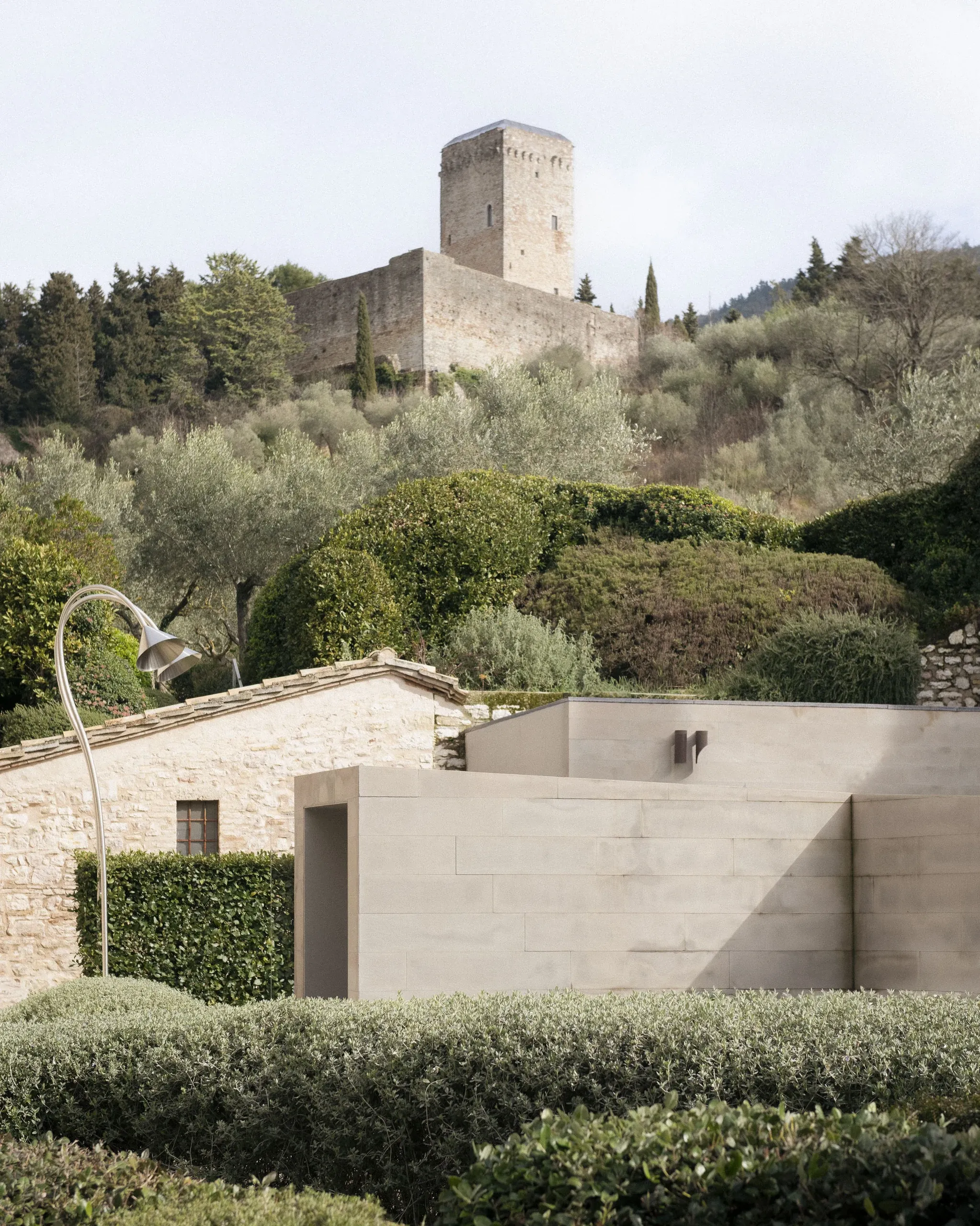 Modern minimal smooth stone walls with Rocca on hill behind