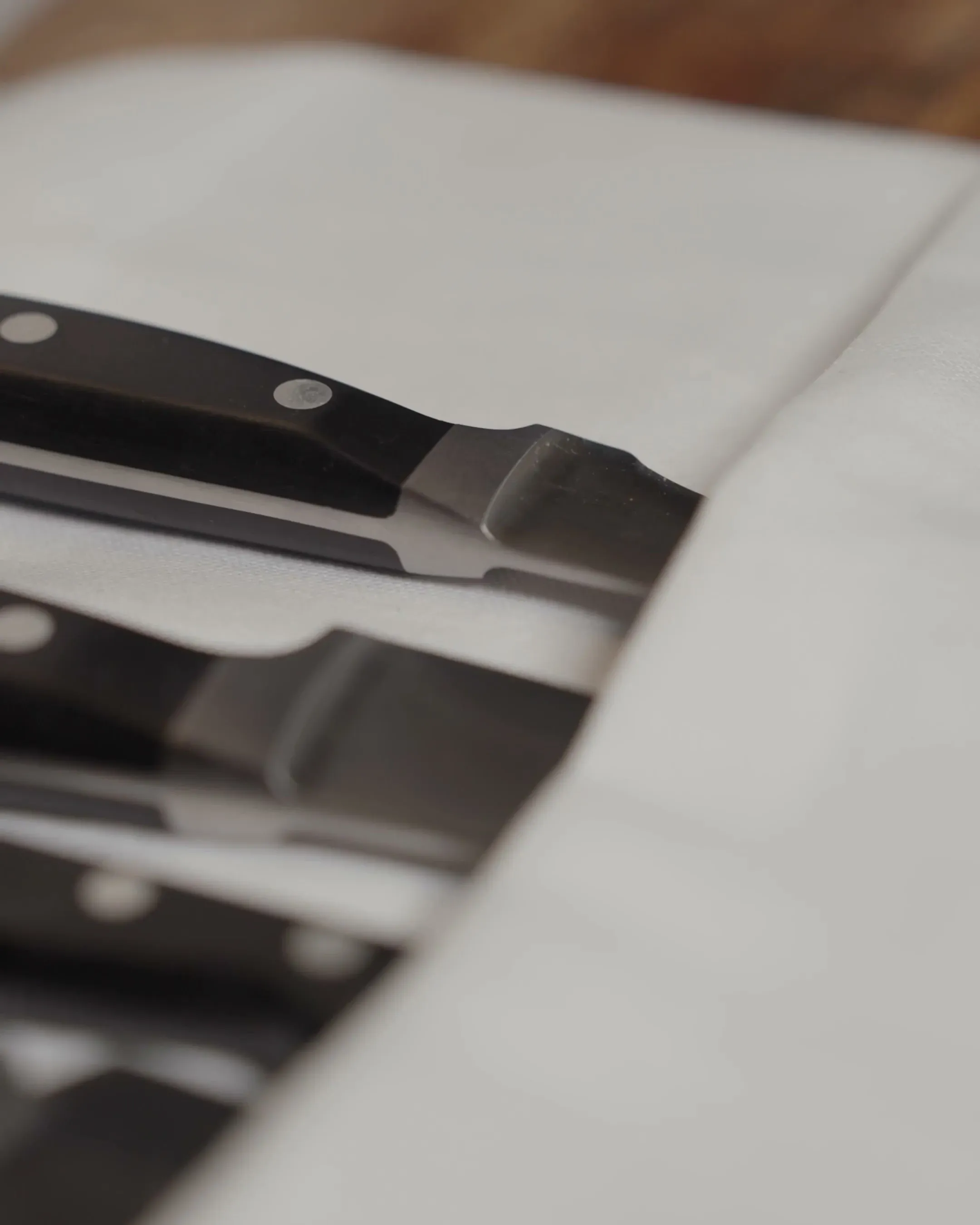 Macro of restaurant steak knives on white linen (video)